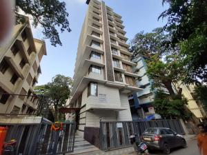 un edificio alto con una macchina parcheggiata di fronte di Mumbai House Luxury Apartments Santacruz East, Mumbai a Mumbai