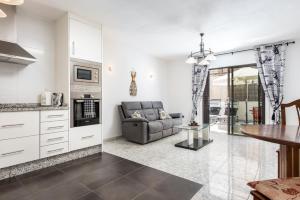 a kitchen and living room with a couch and a table at Victoria Court Modern 1 Bed Apartment Los Cristianos Tenerife in Los Cristianos