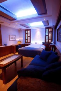 a bedroom with a bed and a couch in a room at WATER HOTEL Cy (Audlt Only) in Machida