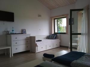 um quarto com uma cama, uma cómoda e uma janela em Chamedafne w Puszczy Kampinoskiej em Brochów