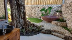 a bathroom with a sink and a tree and a tub at Jungle Paradise in Nusa Penida