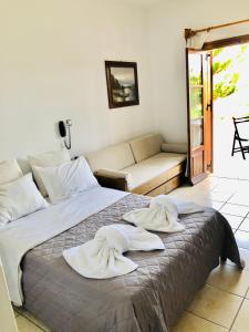 a bedroom with a bed with towels on it at Batistas Apartments in Naousa