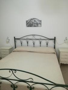 サン・パンクラーツィオ・サレンティーノにあるcasa annafedeのベッドルーム1室(ブラックメタルフレームのベッド1台付)