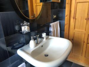 uma casa de banho com um lavatório branco e um espelho. em Dimora Sofia em Monopoli