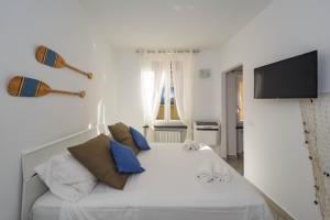 a bedroom with a white bed with blue pillows at Brand New Apt in the Heart of Portofino in Portofino