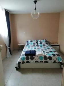 a bedroom with a bed with a polka dot blanket at Chez Laurent in Bergerac