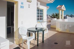 une table et des chaises sur le balcon d'une maison dans l'établissement Apartamentos Sereia da Oura, à Albufeira