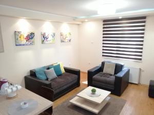 a living room with two chairs and a table at Fortress Apartments in Novi Sad
