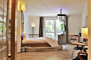 a bedroom with a bed and a large window at Hotel Wutzschleife in Rötz