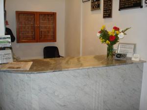 a marble counter with a vase of flowers on it at Hotel Alcazar in Buenos Aires