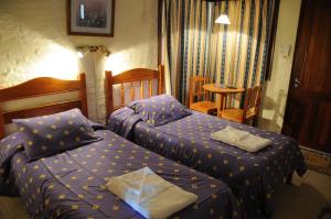 a bedroom with two beds and a table at Arapey Oasis Termal Hotel in Termas del Arapey