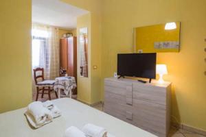 een slaapkamer met een bed en een televisie op een dressoir bij La Collina in Salerno