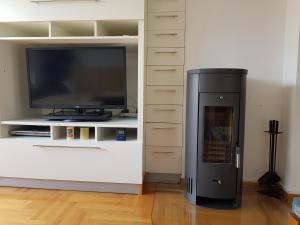 a black refrigerator next to a tv and a entertainment center at Lav apartments in Banja Luka