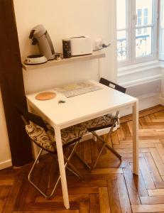a white table and a chair in a room at 9M en plein centre de Lyon visite à pied in Lyon