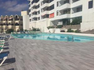 una piscina di fronte a un edificio di La Cascada 410 a Puerto Rico de Gran Canaria