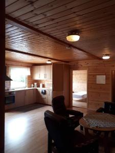 a living room with a table and a kitchen at Fossekroa in Svarstad