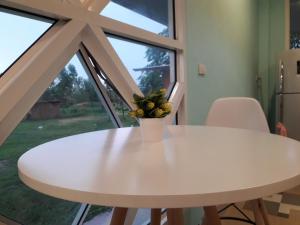 a white table in a kitchen with a window at Wapipathum Earthen House in Ban Na Lao