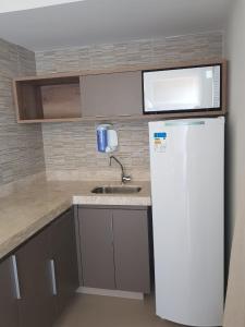 a kitchen with a white refrigerator and a microwave at Park Veredas in Rio Quente