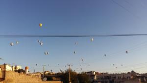 a bunch of kites flying in the sky at Lovely Cappadocia Hotel in Nevsehir