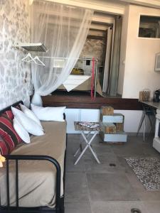 LE CABANON BLEU SUR LA PLAGE في مارسيليا: غرفة نوم مع سرير ونافذة مع ميكروويف