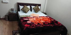 - un lit avec une couverture et des oreillers noirs et rouges dans l'établissement Honix Residency, à Shillong