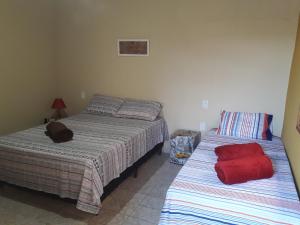 um quarto com duas camas e um saco vermelho na cama em POUSO CALIXTRATO em São João Batista do Glória
