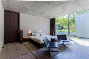 una camera da letto con un letto e due sedie di Notarishuys "Pure Hotel" a Diksmuide