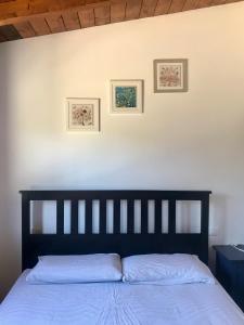 uma cama num quarto com duas fotografias na parede em Alloggio Rurale em Terni