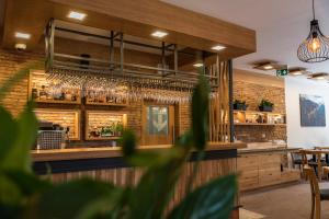 a restaurant with a bar with glasses on the wall at Hotel Jasná in Belá