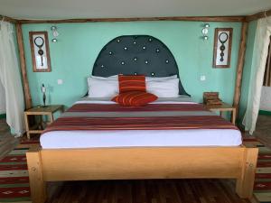 a bedroom with a large bed with a large headboard at Samuka Island Retreat in Jinja