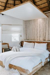una camera da letto con un grande letto bianco con cuscini bianchi di Qambathi Mountain Lodge a Rev Estates