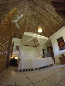 1 dormitorio con 1 cama con techo de paja en Casa Aditi, en Mazunte