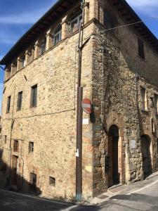 un antiguo edificio de piedra con una puerta y un poste en Loft De' Riccardi, en Chianni