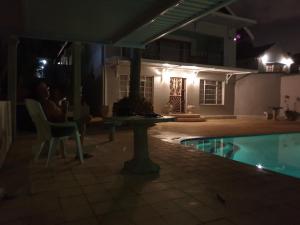 a person sitting in a chair next to a pool at night at 100 on Girvan in Durban