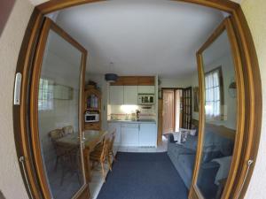 uma sala de estar com uma mesa e um espelho grande em 2 pièces avec terrasse Morillon Village em Morillon
