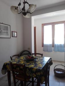 a dining room table with a bowl of fruit on it at Casa della camperia in Favignana