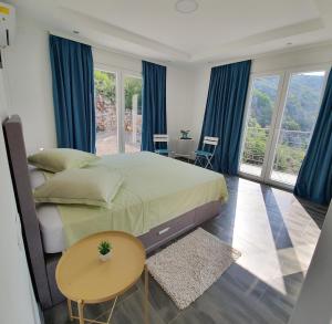 a bedroom with a large bed with blue curtains at Private Sea View with Infinity Pool in VILLA NERIN Zagora in Zagora +37 photos