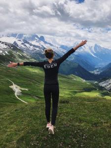 a woman standing on top of a mountain with her arms out at Eden Hotel, Apartments and Chalet Chamonix Les Praz in Chamonix-Mont-Blanc