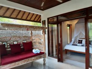 a bedroom with a bed and a red bench at Hidden Point Villa in Ubud