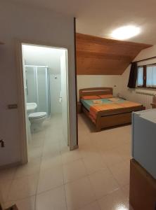 a bedroom with a bed and a bathroom with a toilet at Casa da Emanuela in Drežnik Grad