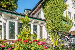una bicicleta estacionada frente a una casa con flores en Pension Linde Prerow, en Prerow