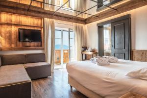 een slaapkamer met een groot bed en een tv bij Alp Wellness Sport Hotel Panorama in Fai della Paganella +200 foto's