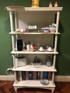 a white book shelf with food and dishes on it at B&B Country Dreams in Sulmona