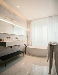 La salle de bains est pourvue d'une baignoire et d'un lavabo. dans l'établissement Roi de Sicile - Rivoli -- Luxury apartment hotel, à Paris