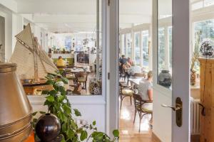 a room with people sitting at tables in a restaurant at Pension Linde Prerow in Prerow