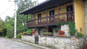 un bâtiment avec un balcon sur un mur en pierre dans l'établissement Xuegu la bola, à Ceceda de Abajo
