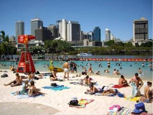 a group of people on a beach in the water at Chill Backpackers in Brisbane