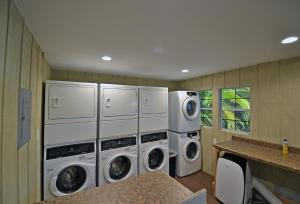 a laundry room with three washer and dryer at Siesta Heron Suites & Villas in Siesta Key