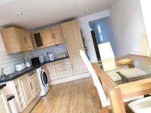 een keuken met houten kasten en een tafel en een eetkamer bij Number One in Wetherby