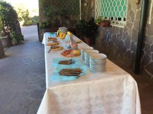 una mesa larga con platos y comida. en Villa Covaccioli Schimperna, en Formello